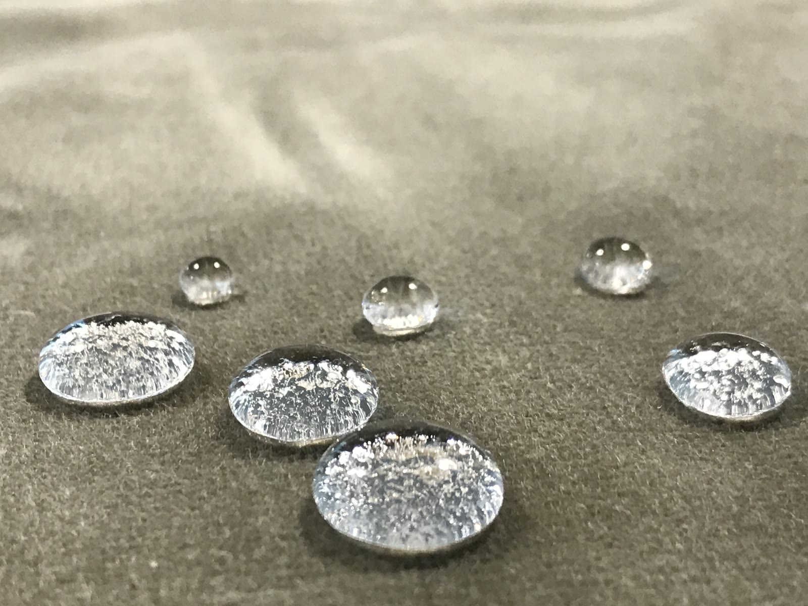 Impregnering av sofa og tepper: vanndråper perler på behandlet tekstil