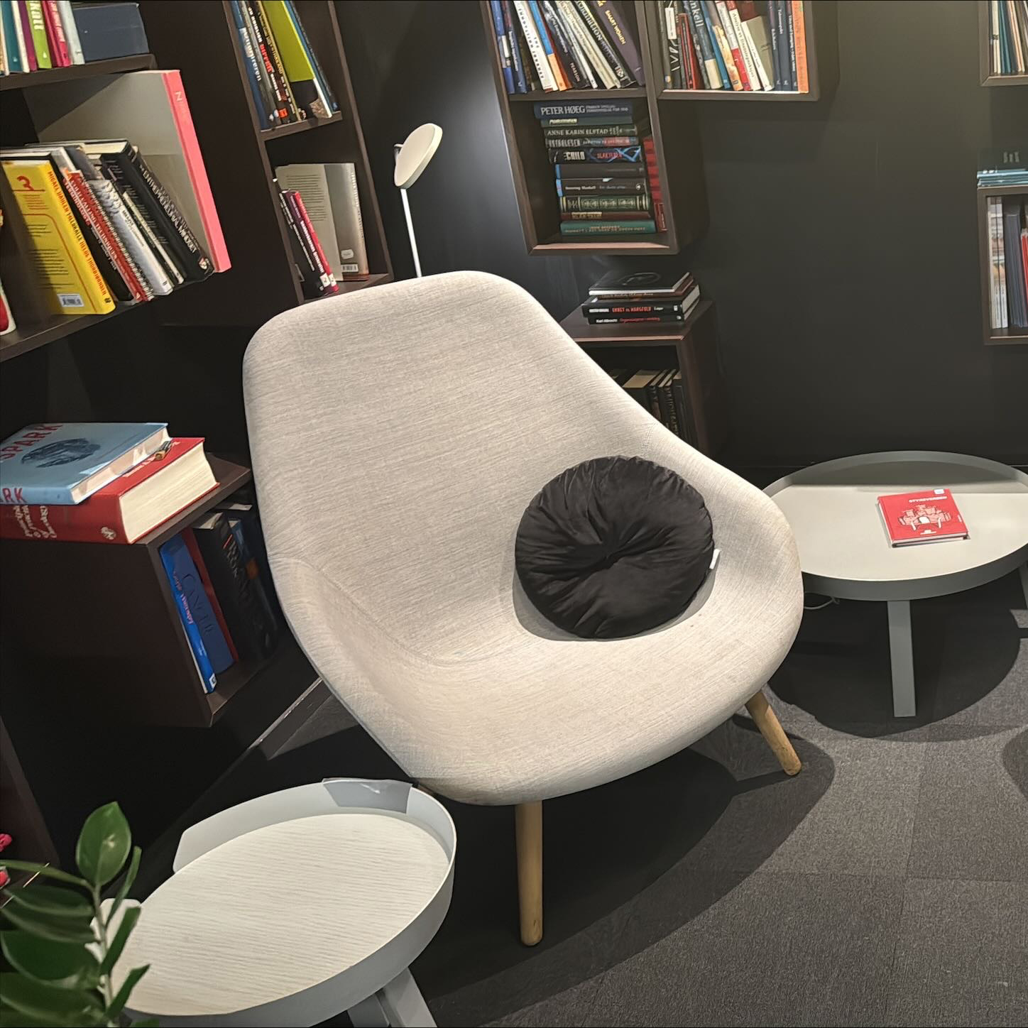 Kontor-bibliotek med lyse lenestoler i tekstil og bokhyller