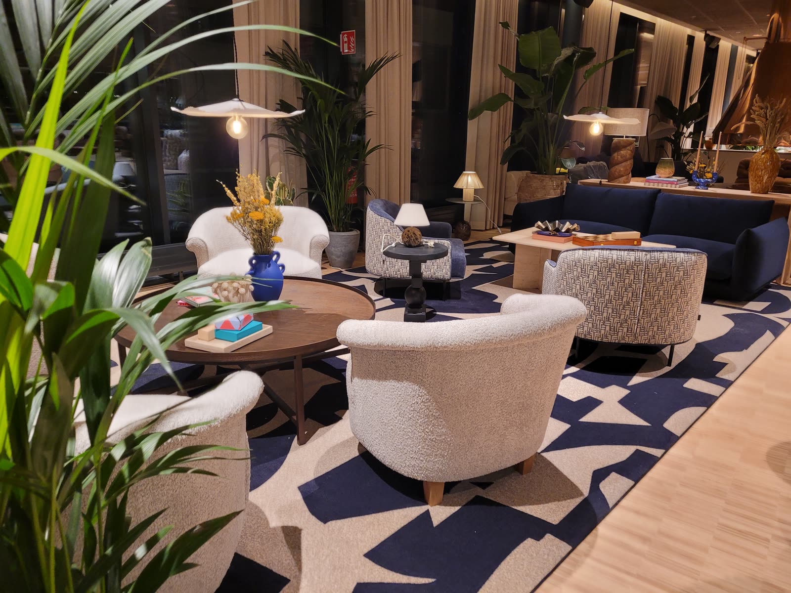 Lobby-lounge med boucle-stoler og mønstret teppe