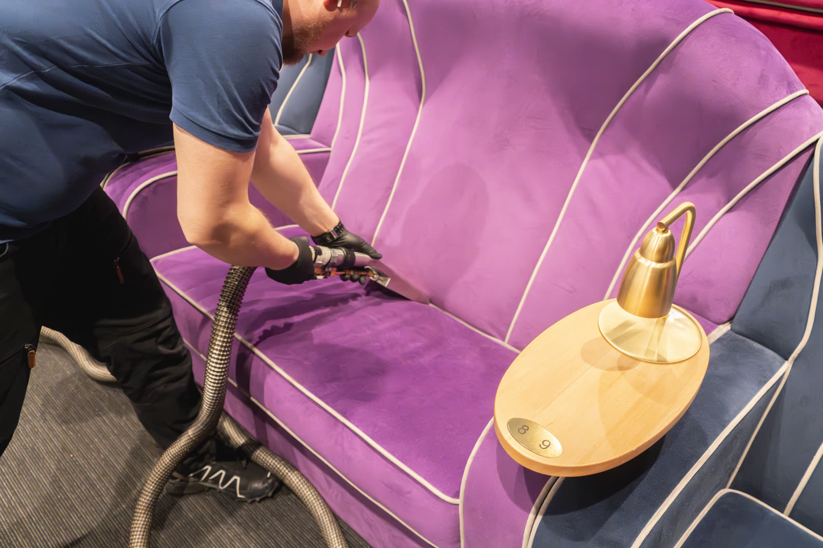 Fiber ProTector-tekniker dyprenser fiolett velur-sofa i kino