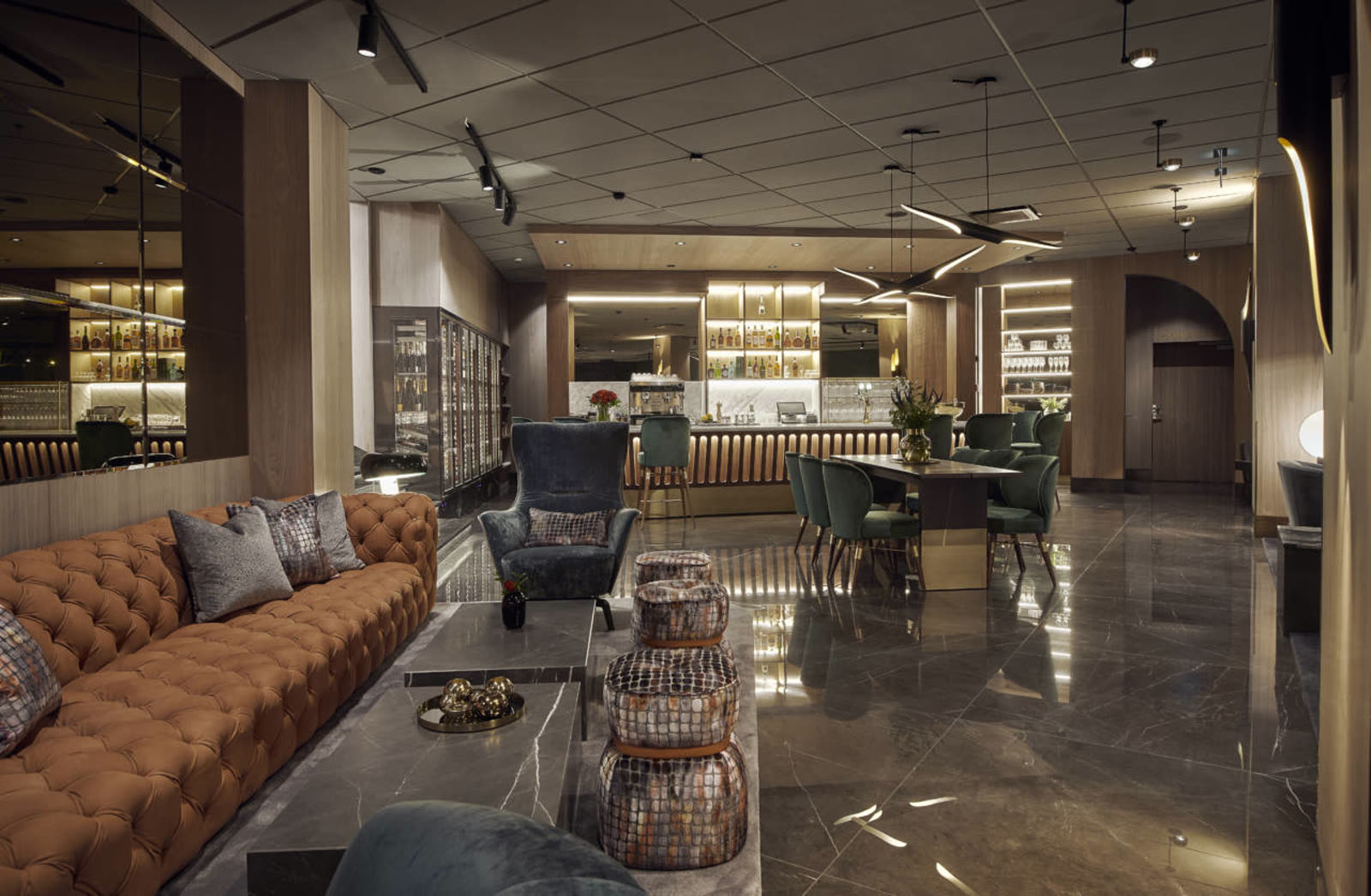Marmor bar-lounge med kurvet velur-sofa og krokodilleskinn-ottomans
