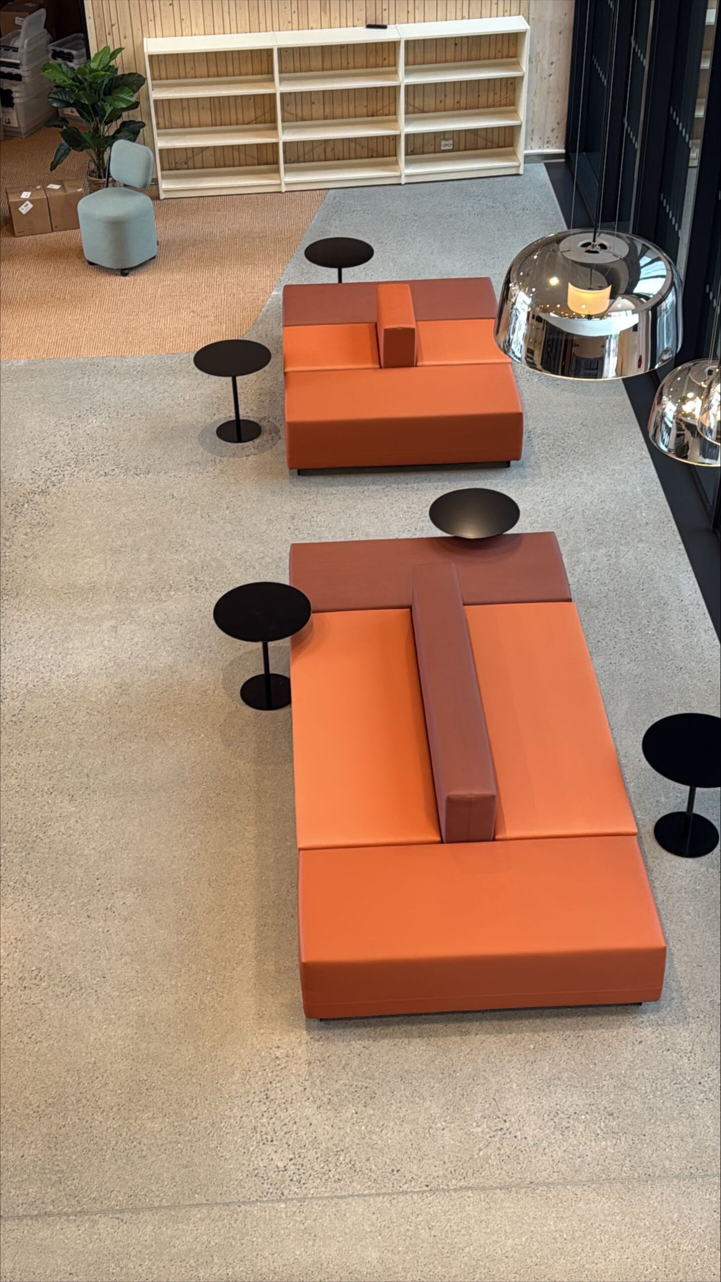 Skolens loungeområde med oransje sofamoduler og teppe