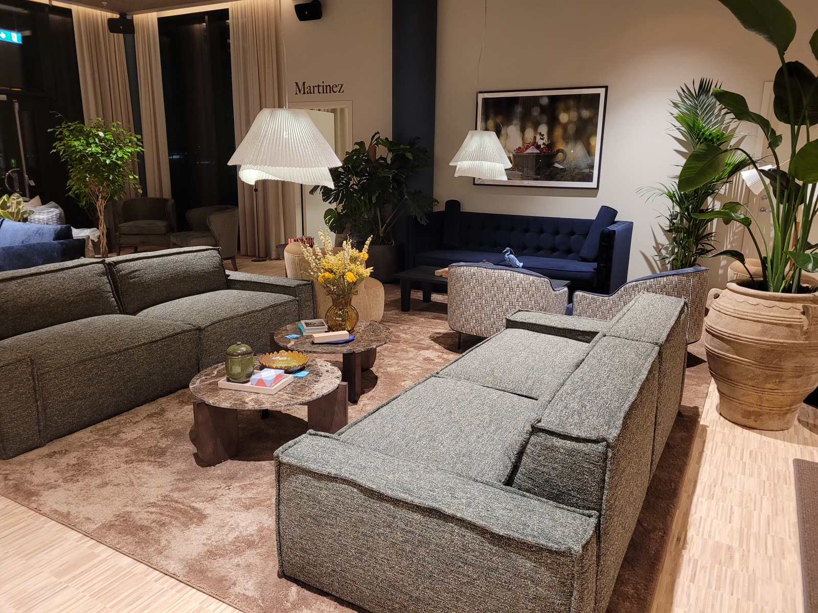 Suite-lounge med marineblå velur-sofa og boucle-stoler